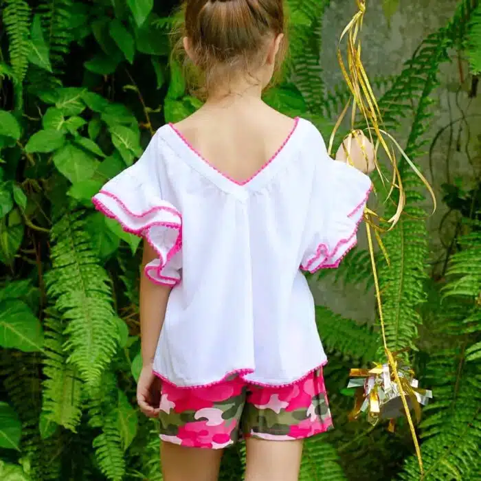 Jolie blouse blanche été fille, coupe ample et confortable, à manches papillon. Originale avec sa double rangée de volants sur les manches bordés de pompons rose fuchsia. Col V dans la nuque, bas de la blouse soulignés de pompons rose fuchsia. Blouse été pour filles, fillettes et ados de 2 à 16 ans, de la marque de mode pour enfants LA FAUTE A VOLTAIRE