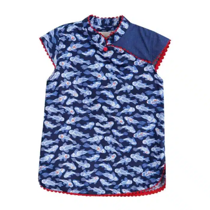Blouse chinoise en coton imprimé poissons Khoi bleu marine, bleu clair et rouge. Les manches courtes coupées en biais, le col Mao et le bord de la blouse bordée de biais rouge. Blouse asiatique pour filles, fillettes et ados de la marque de mode pour enfants LA FAUTE A VOLTAIRE