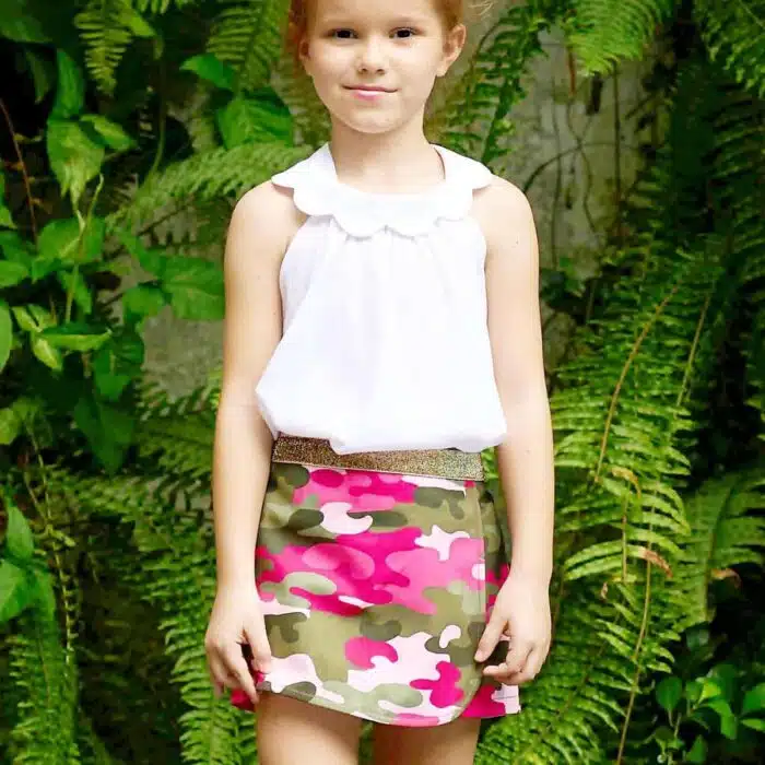 Jolie jupe portefeuille à l'imprimé camouflage rose et kaki qui cache un short. Très tendance et féminine avec sa ceinture intégrée à paillettes dorées. Taille ajustable avec élastique intérieur. Jupe short pour filles, fillettes et ados de 2 à16 ans de la marque de mode pour enfants LA FAUTE A VOLTAIRE