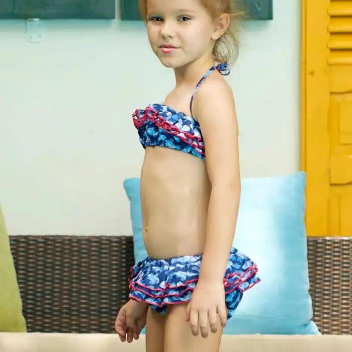 Maillot de bain deux pièces à volants en coton imprimé japonisant de poissons Khoi bleu marine, blanc et rouge. Haut du maillot forme bandeau à volant avec élastique dans le dos et bas du maillot coupe taille basse à volants. Maillot de bain deux pièces pour filles, fillettes et ados de la marque de mode pour enfant LA FAUTE A VOLTAIRE
