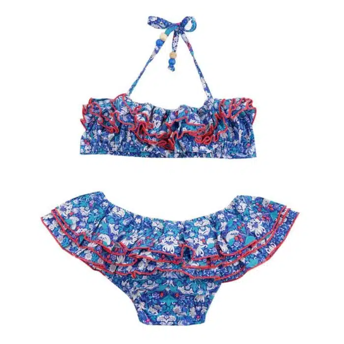 Maillot de bain deux pièces à volants en coton imprimé fleurs et oiseaux bleu, blanc et rouge. Haut du maillot forme bandeau à volant avec élastique dans le dos et bas du maillot coupe taille basse à volants. Maillot de bain deux pièces pour filles, fillettes et ados de la marque de mode pour enfant LA FAUTE A VOLTAIRE