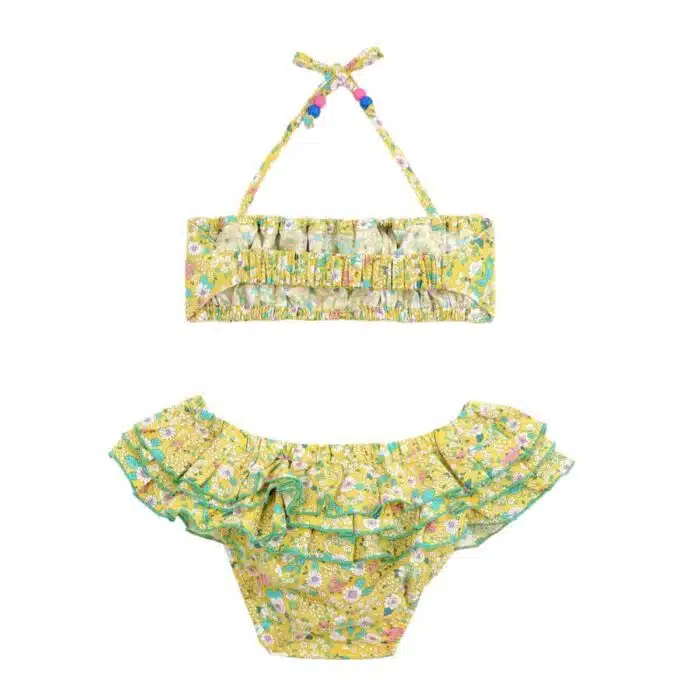 Maillot de bain deux pièces à volants en coton fleuri jaune et vert. Haut du maillot forme bandeau à volant avec élastique dans le dos et bas du maillot coupe taille basse à volants. Maillot de bain deux pièces pour filles, fillettes et ados de la marque de mode pour enfant LA FAUTE A VOLTAIRE