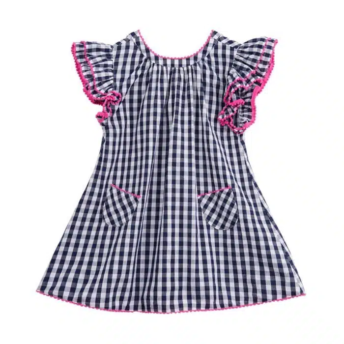 Jolie robe à carreaux vichy bleu marine et blanc, à manches papillons à volants, col rond devant et col V dans la nuque, rangée de pompons rose fuchsia autour des volants, col et bas de la robe. Robe été pour filles, fillettes et ados de la marque de mode pour enfants La Faute à Voltaire
