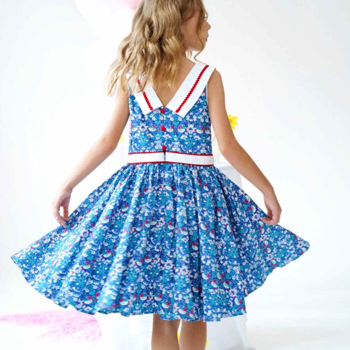 On Craque pour cette Magnifique Robe Qui Tourne Bleu Foncé à l'Imprimé Fleuri Liberty avec Fleurs, Oiseaux blanc et Rouge. Robe d'Été Sans Manche avec Col Bateau Blanc en V dans la Nuque avec Ruban Zigzag Rouge, Taille Cintrée avec Ceinture Intégrée Blanche Bordé de Zigzag Rouge. Deux Poches Invisibles sur les Côtés. Parfaite pour une Cérémonie Religieuse comme un Mariage ou une Fête de Famille, une Garden Party. Robe Qui Tourne pour Filles, Fillettes, Ados de 2 à 16 ans. Livraison Rapide 24-72h Offerte pour Tout achat Supérieur à 60€. Marque de Mode Créateur Française Produite en Commerce Équitable La Faute à Voltaire.