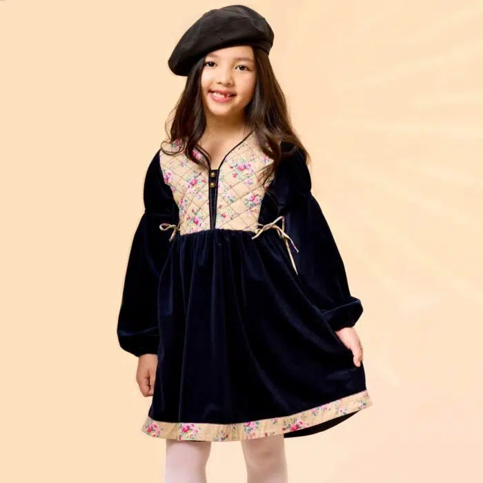 On Craque pour cette Élégante et Originale Robe d'Hiver pour Fille en Velours Millerais Bleu Marine et plastron matelassé en Fleuri Liberty Beige et Rose de la Marque de Mode pour Enfant La Faute à Voltaire.