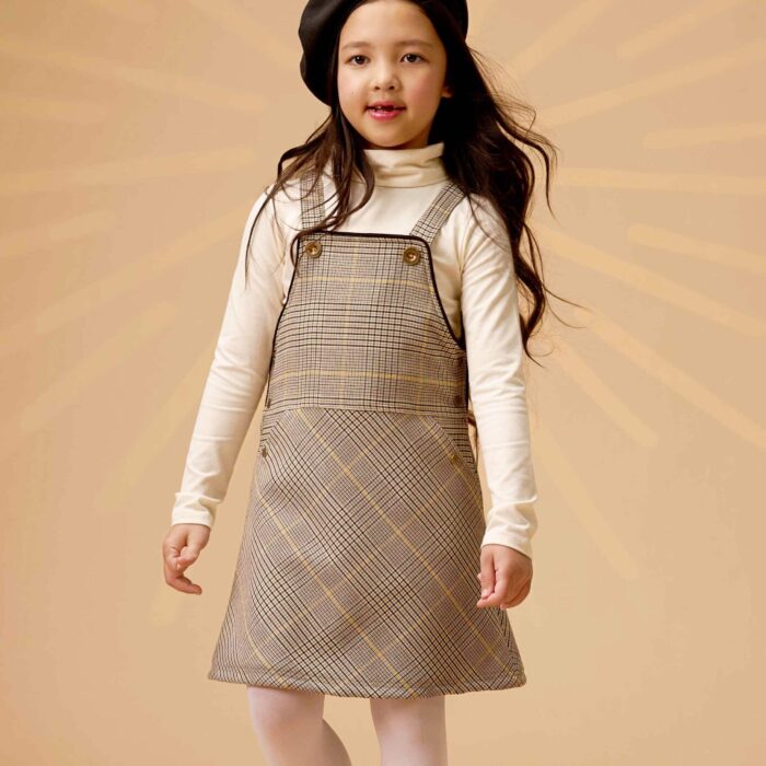 On Craque pour cette Magnifique Rose Salopette pour Fille et. Fillette en Laine Carreaux Tartan avec Fils Marron, beige et Jaune. Robe Salopette à l'esprit très British, elle se porte au-dessus du genou ou mi-cuisse. Modèle de la Marque de Mode Enfant La Faute à Voltaire.