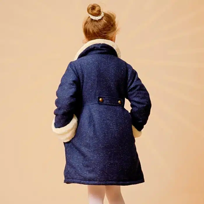 Un Magnifique Manteau Chaud et Long en Laine Tweed Bleu Marine avec Col et Poignets en Fausse Fourrure toute Douce Beige. Cet élégant Manteau est. doublé de Coton fleuri Liberty Jaune et Bleu Ciel. Evolutif, ce Manteau se porte mi-genou ou jusqu'à 10 cm au dessus du genou. Les manches bordées de fausse fourrure se retournent pour s'adapter à la longueur de votre enfant. Ainsi ce manteau évolutif se porte deux années très facilement et est très économique. Manteau de la Marque de Mode Vêtements Chic pour Enfant La Faute à Voltaire.