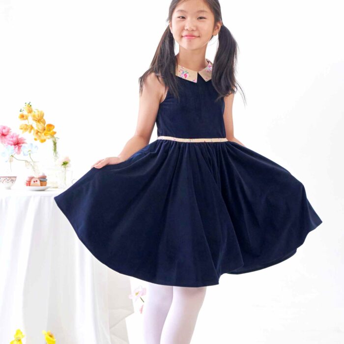Idéale pour la Rentrée Scolaire ainsi que les Cérémonies de l'Automne-Hiver ou même en Robe de Noël sur le Thème du Bleu, pour toutes les Jeunes Filles et Fillettes de 2 à 16 ans, une Robe qui Tourne en Velours Millerais Bleu Marine à Col Claudine Pointu en Coton Fleuri Liberty Beige et Rose et Biais à la Ceinture Assorti de la Marque de Mode Française pour Enfant c'est La Faute à Voltaire.