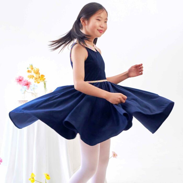 Idéale pour la Rentrée Scolaire ainsi que les Cérémonies de l'Automne-Hiver ou même en Robe de Noël sur le Thème du Bleu, pour toutes les Jeunes Filles et Fillettes de 2 à 16 ans, une Robe qui Tourne en Velours Millerais Bleu Marine à Col Claudine Pointu en Coton Fleuri Liberty Beige et Rose et Biais à la Ceinture Assorti de la Marque de Mode Française pour Enfant c'est La Faute à Voltaire.