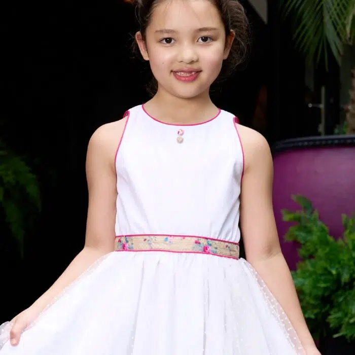 Une Magnifique Robe de Cérémonie Qui Tourne en Coton Blanc Contrasté de Coton Fleuri Liberty Beige et Rose, et de Tulle Blanche sur la Jupe. Un Gros noeud Fleuri Amovible dans le Dos. Robe demoiselle d'honneur pour Fille, Fillette de 2 à 16 ans de la Marque de Mode Enfantine La Faute à Voltaire.