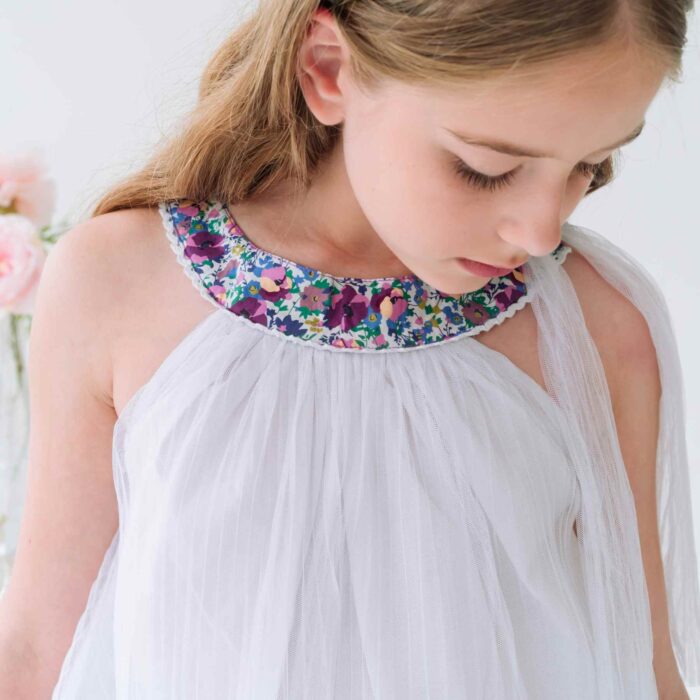 Une Belle Cérémonie cet Été ? Offrez cette Magnifique Robe Blanche de Coupe Ample avec Col Rond Fleuri Liberty Violet, Bleu, Mauve et Dentelle Blanche pour Filles, Fillettes et Ados de 2 à 16 ans de la Marque de Mode Chic Française pour Enfants La Faute à Voltaire.