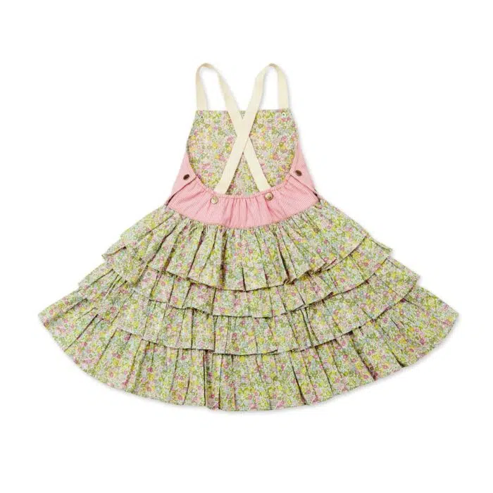 Une adorable Robe Salopette Printemps été pour Fille avec Plastron avant en Coton Rose et jupe à volants fleuris liberty rose et vert. Bretelles croisées dans le dos. Ouverture avec boutons pressions dans sur les côtés. Modèle de la marque de mode pour enfants LA FAUTE A VOLTAIRE.