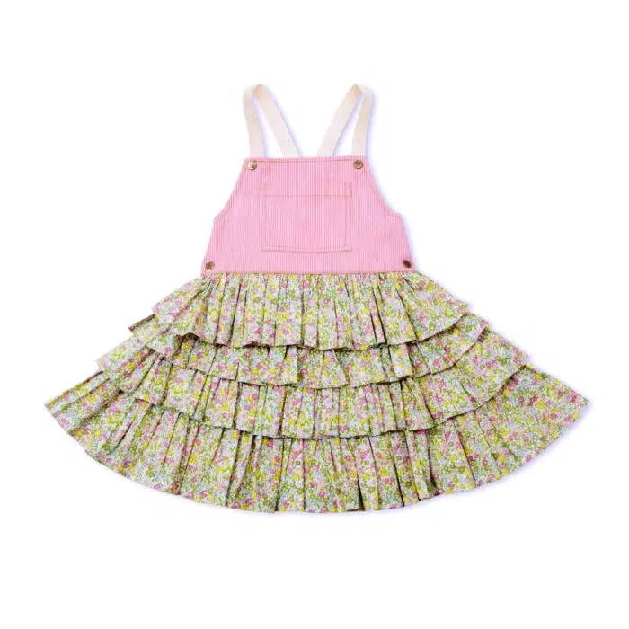 Une adorable Robe Salopette Printemps été pour Fille avec Plastron avant en Coton Rose et jupe à volants fleuris liberty rose et vert. Bretelles croisées dans le dos. Ouverture avec boutons pressions dans sur les côtés. Modèle de la marque de mode pour enfants LA FAUTE A VOLTAIRE.