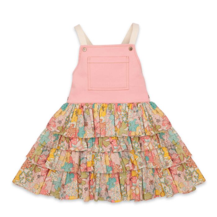 Une adorable Robe Salopette Printemps été pour Fille avec Plastron avant en Coton Rose et jupe à volants fleuris liberty dans les tons abricot, jaune, vert. Bretelles croisées dans le dos. Ouverture avec boutons pressions dans sur les côtés. Modèle de la marque de mode pour enfants LA FAUTE A VOLTAIRE.