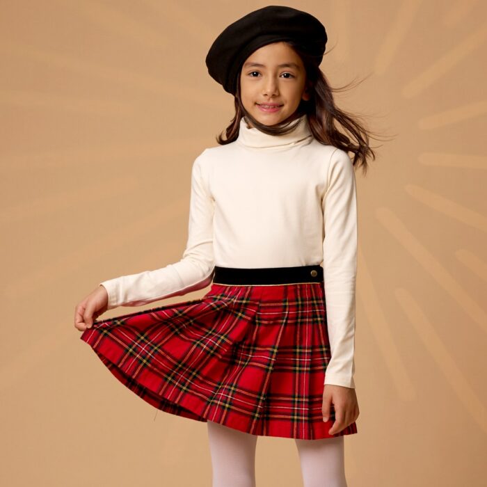 Un magnifique ensemble hivernale pour les filles et fillettes composé d'une élégante jupe plissée à carreaux tartan au style écossais et un délicat pull col roulé beige tout doux de la marque de mode pour enfants LA FAUTE A VOLTAIRE