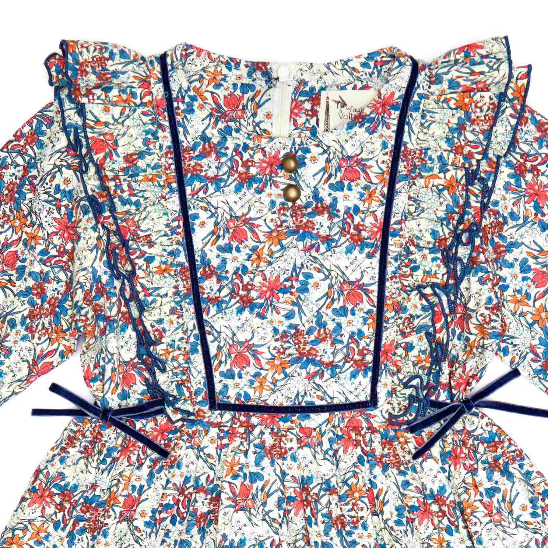 robe liberty fleurie bleu à volants aux emmanchures, à manches longues avec élastique aux poignets et détails en velours bleu. Marque mode enfant LA FAUTE A VOLTAIRE