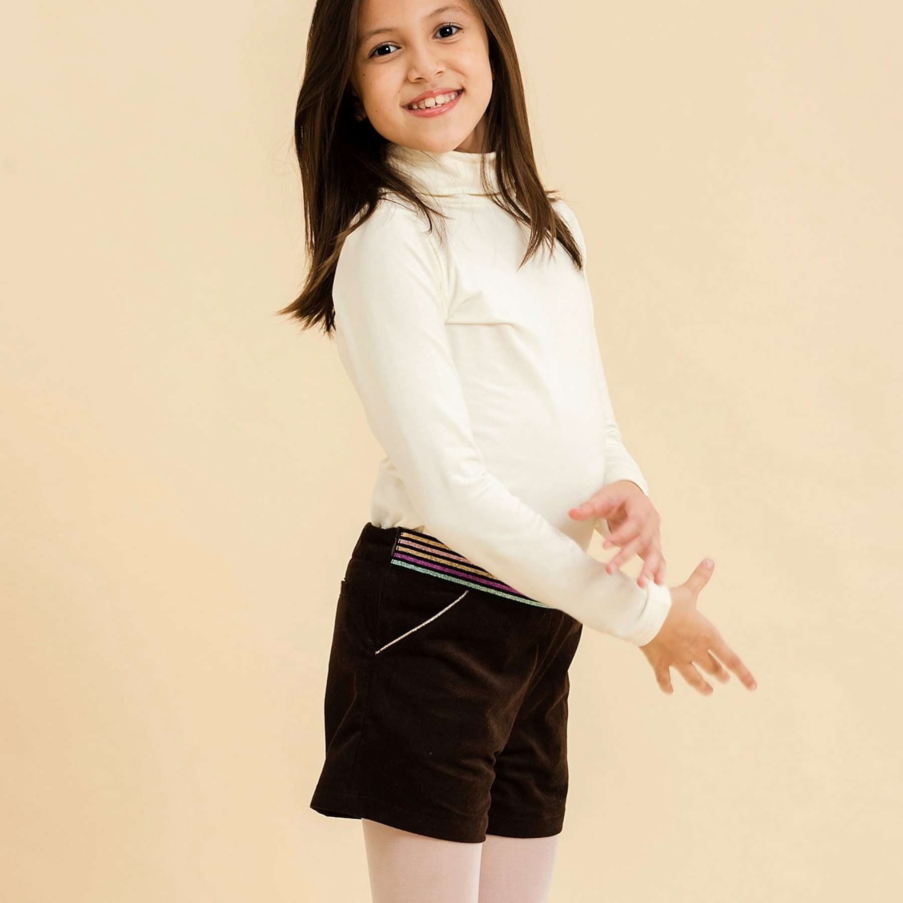 Magnifique ensemble d'Hiver pour Filles, un Pull Col Roulé en Coton Beige Manches Longues , avec un Short Glamour en Velours Marron Chocolat et une Ceinture à Paillettes Multicolores. Collection Automne Hiver de la Marque de Mode pour Enfants LA FAUTE A VOLTAIRE.