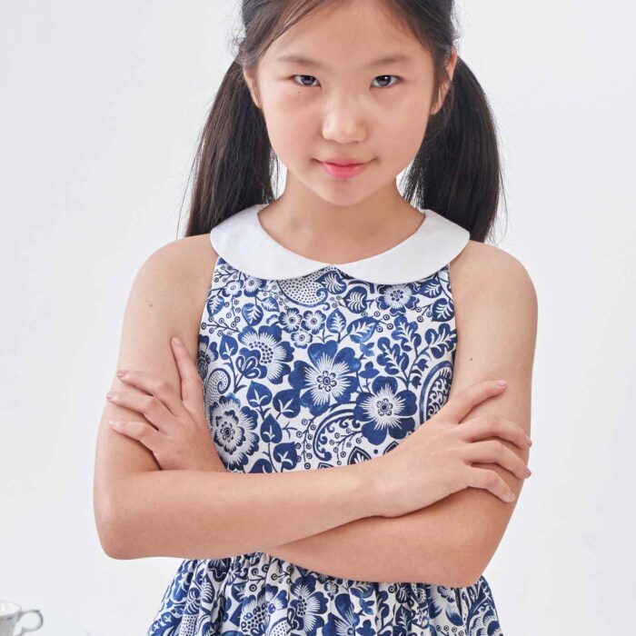 Une Magnifique Robe Patineuse Été pour Fille et Fillette en Coton Fleuri Bleu Marine et Blanc, Col Claudine Blanc, Ceinture avec Zigzag Bleu Marine. Robe Qui Tourne et Noeud dans le Dos Idéale pour les Cérémonie, Tenue de mariage Enfant, Robe Chic pour la Rentrée Scolaire de la Marque de Mode Chic pour Enfant La Faute à Voltaire