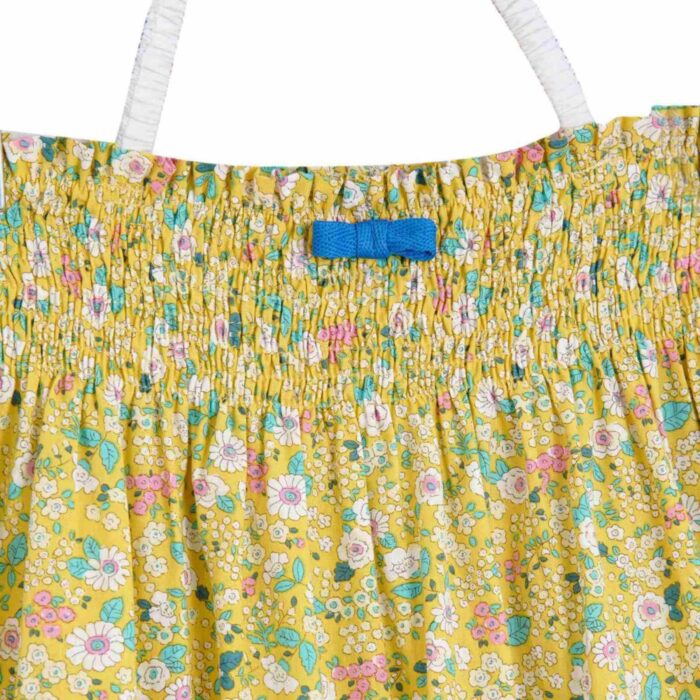 Magnifique Robe Été Coupe Large Longueur Midi en coton Fleuri Liberty Jaune, Volants Blancs et Pompons Bleu roi en Bas de la Jupe. Col Smocks Extensible. Robe Évolutive Deux-en-Un se porte façon Robe Midi ou façon Jupe Bohème Longue à Volants avec un petit Haut Blanc Assorti. Création Mode Printemps Été pour Filles, Fillettes et Ados de la Marque de Mode Française Chic pour Enfant La Faute à Voltaire.