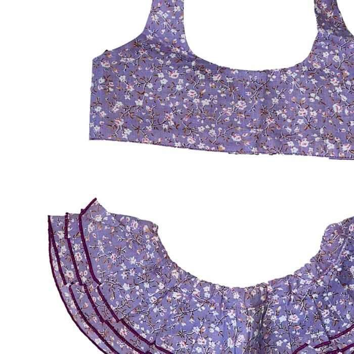 Maillot de bain deux pièces à volants en coton fleuri violet et bleu. Haut du maillot forme bandeau à volant avec élastique dans le dos et bas du maillot coupe taille basse à volants. Maillot de bain deux pièces pour filles, fillettes et ados de la marque de mode pour enfant LA FAUTE A VOLTAIRE