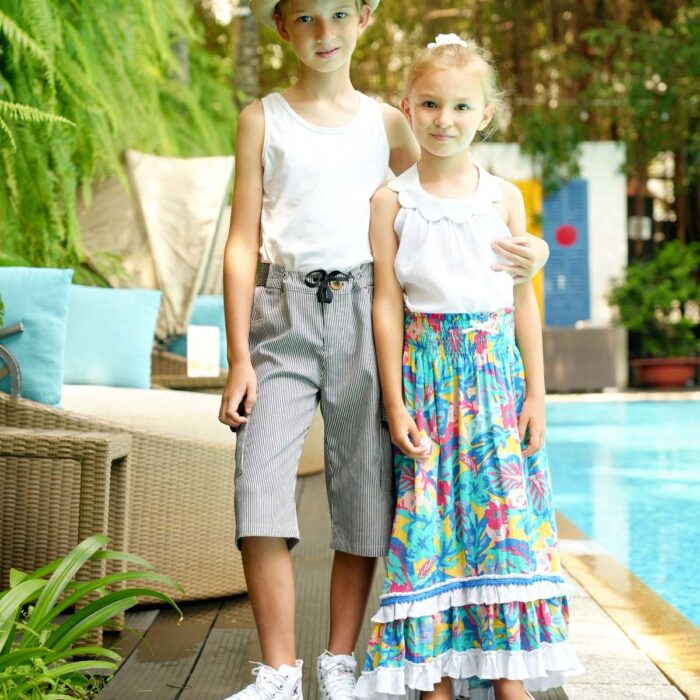 Jupe longue de plage deux en un pour fille à fleurs hawaii couleur bleu vert, rose et jaune, col smocks, qui se porte en robe. De la marque de mode pour enfant LA FAUTE A VOLTAIRE