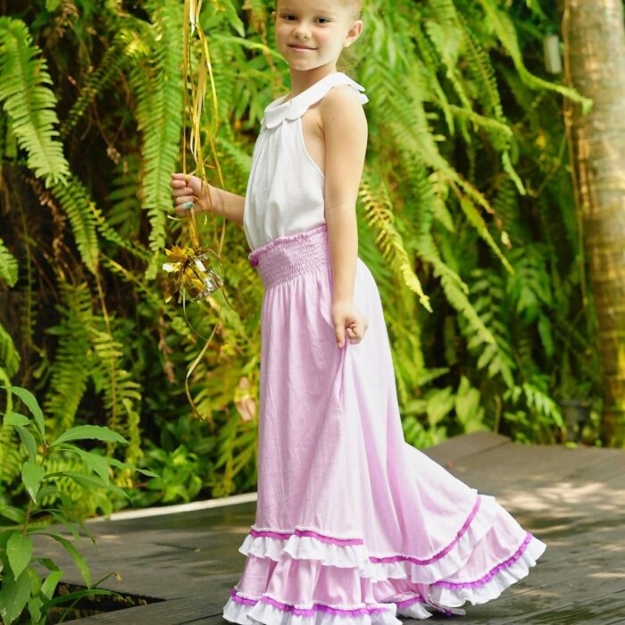 Robe jupe longue de plage deux en un pour fille, fillette et ado imprimé géométrique rose et blanc avec volants en bas de la jupe bordée de dentelle violette, col smocks, modèle robe jupe de plage de la marque de mode pour enfant LA FAUTE A VOLTAIRE