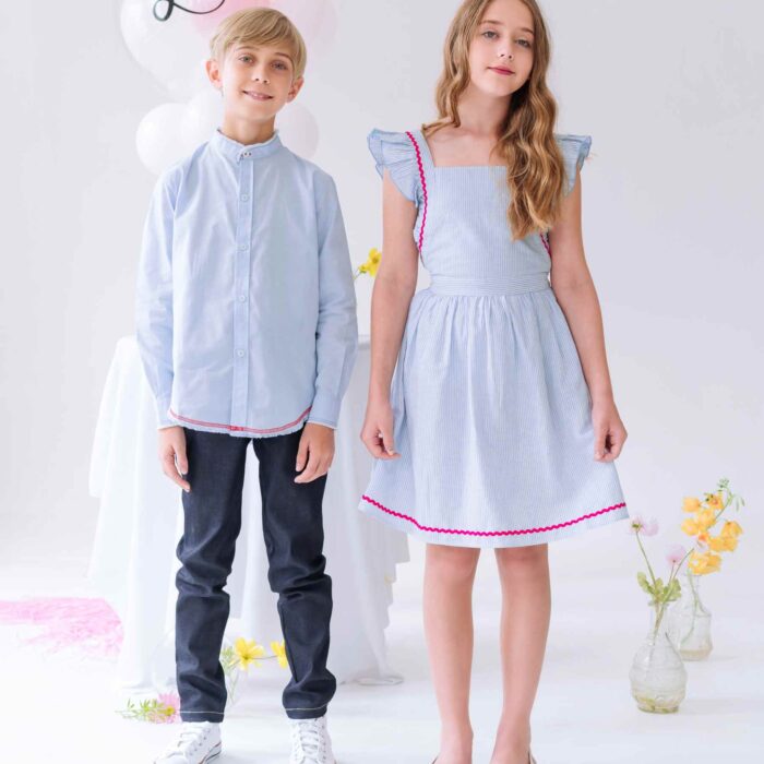 Une élégante Tenue de Mariage pour Enfant avec un Pantalon Jeans Denim Coupe Slim Fit Couleur Bleu Foncé, ainsi qu'une Chemise Col Officier Bleu Ciel avec Surpiqûres Rouge. Collection Cérémonie Mode Enfant de la Marque de Mode Chic et Tendance Française La Faute à Voltaire.