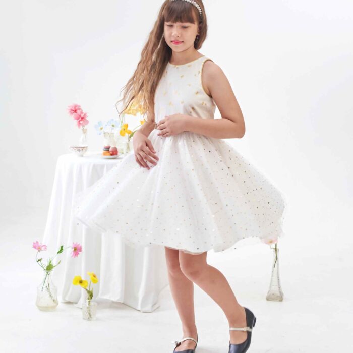Vous Recherchez une Robe Blanche et Or pour un Mariage ? Une Soirée ? Un Anniversaire à Célébrer en Été ou une Robe de Nouvel An pour la Fin d'Année ? Craquez pour cette Robe de Soiré et Fête Polyvalente que toutes les Filles, Fillettes et Ados de 2 à 16 ans pourront Porter et faire Virevolter à l'Infini. Coupée en Demi-Lune et Froncée à la taille, cette Robe Patineuse Tourne à l'Horizontal pour le plus grand Bonheur de votre Princesse. Coupée en 3 Matières : Lin Blanc Imprimé Petits Palmier Dorés sur le Buste, Tulle Blanche à Paillettes Dorées sur la Jupe Doublée de Coton blanc. Emmanchures à l'Américaine Bordés d'un Biais Doré pour Dessiner de Jolies Épaules. Taille Soulignée par une ceinture Fixe en Paillettes Dorée. Cette Robe Forme Trapèze est de la Collection Tenue de Mariage et Fêtes de la Marque de Mode Française pour Enfants C'est la faute à Voltaire.