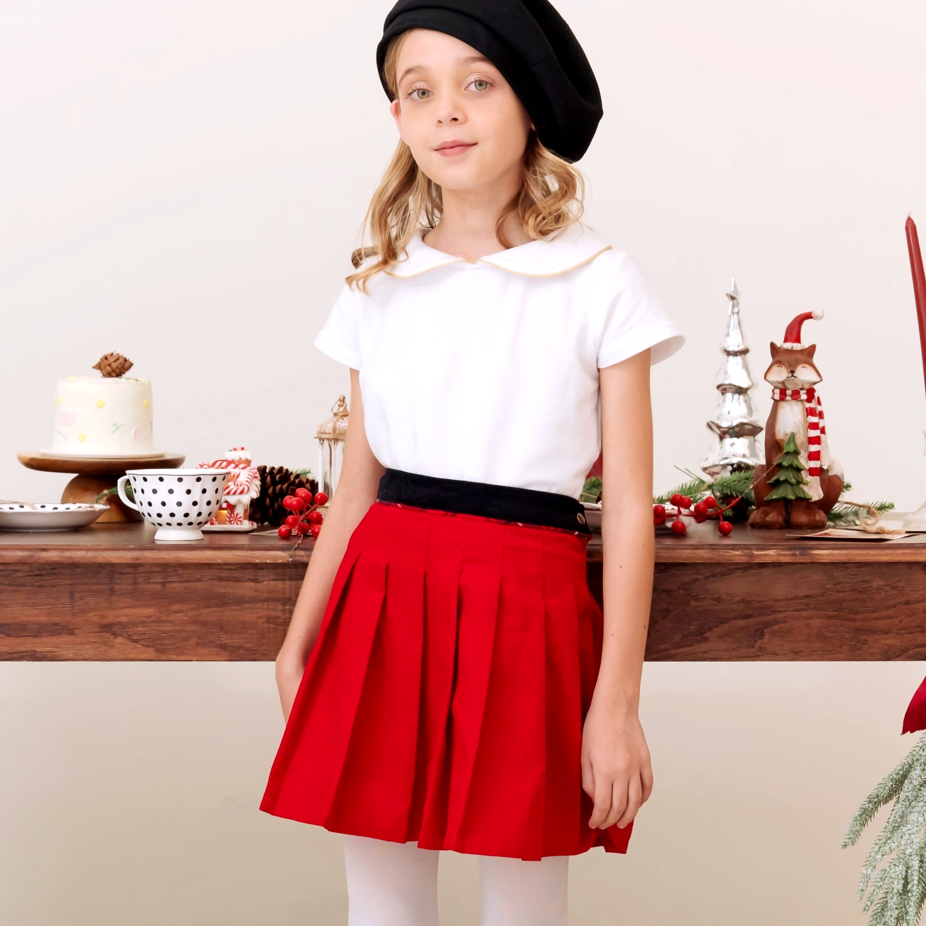 Une Élégante Jupe Plissée en Fin velours Rouge Contrasté d'une Ceinture de Velours Noir avec un petit Biais de Carreaux Tartan Rouge. Idéale en Tenue Chic pour Noël et pour toutes les Sorties Chics en Famille. Modèle de Jupe "London" de la Marque de Mode Française pour Enfants La Faute à Voltaire.