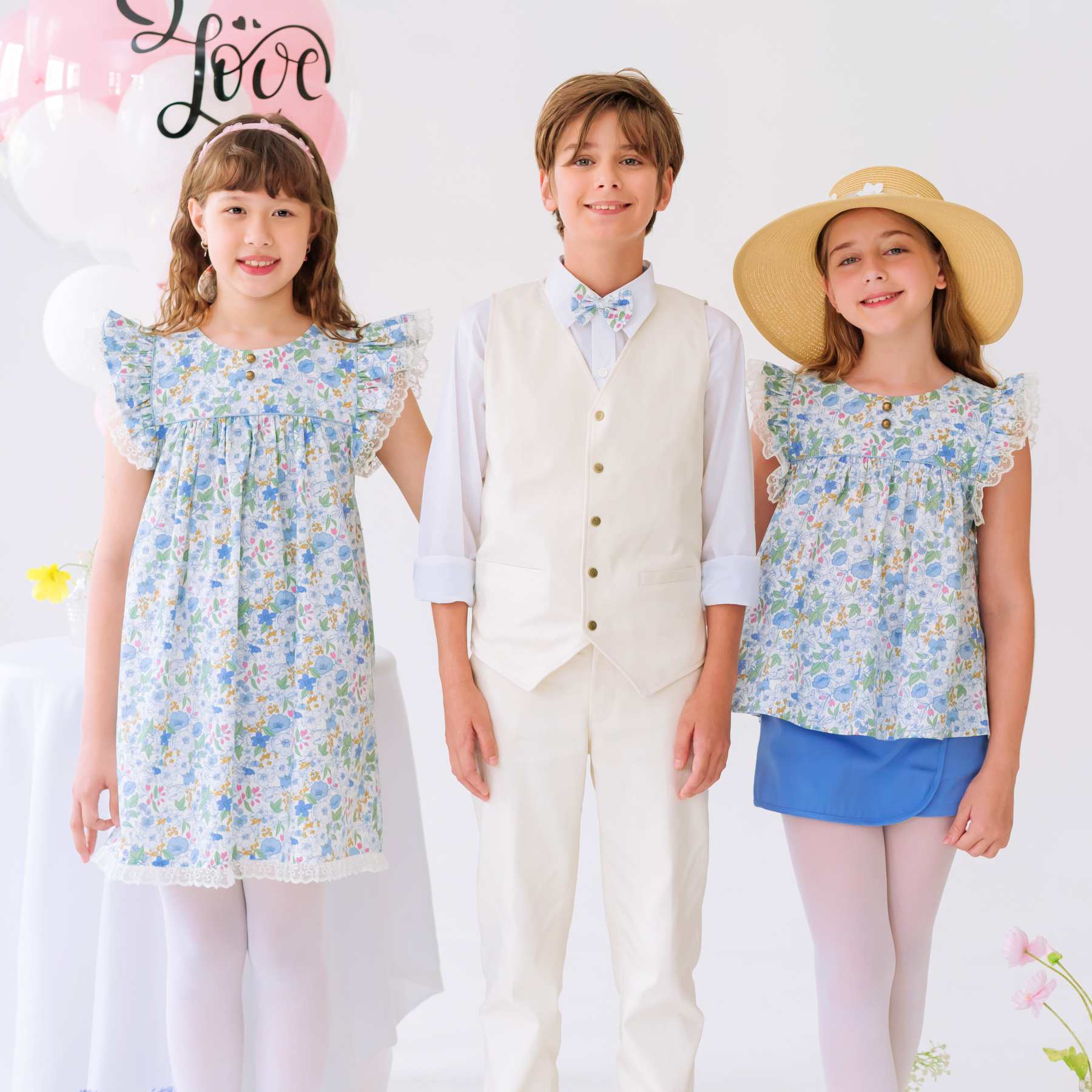 Photos portée tenues de cérémonie portées pour enfant avec costume de mariage pour enfant avec gilet de costume beige et pantalon beige assorti, robes liberty fleuri bleu clair pour filles.