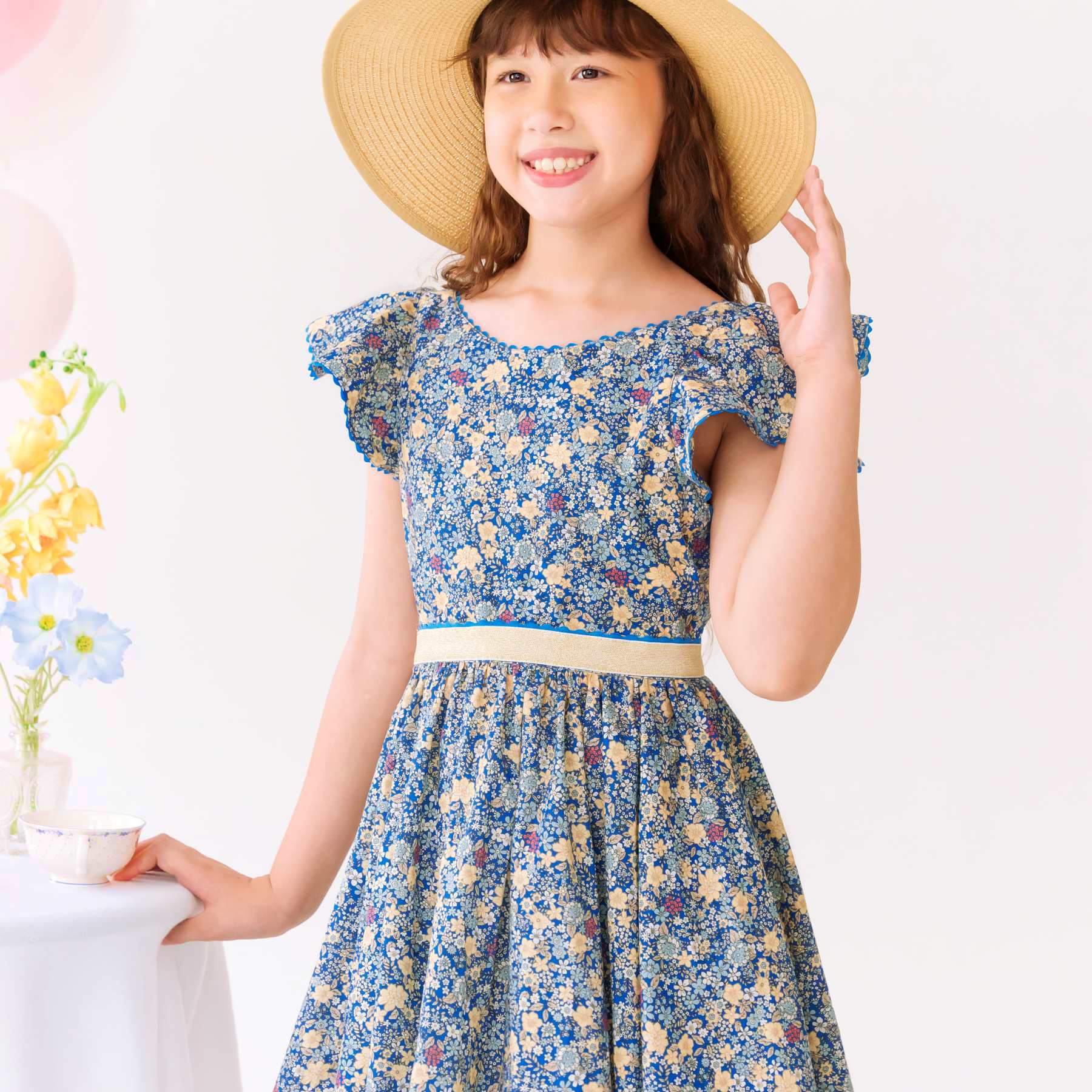 Robe cérémonie fille liberty bleu foncé et jaune avec manches courtes à volants, ceinture doré. Tailles disponibles du 2 au 16 ans.