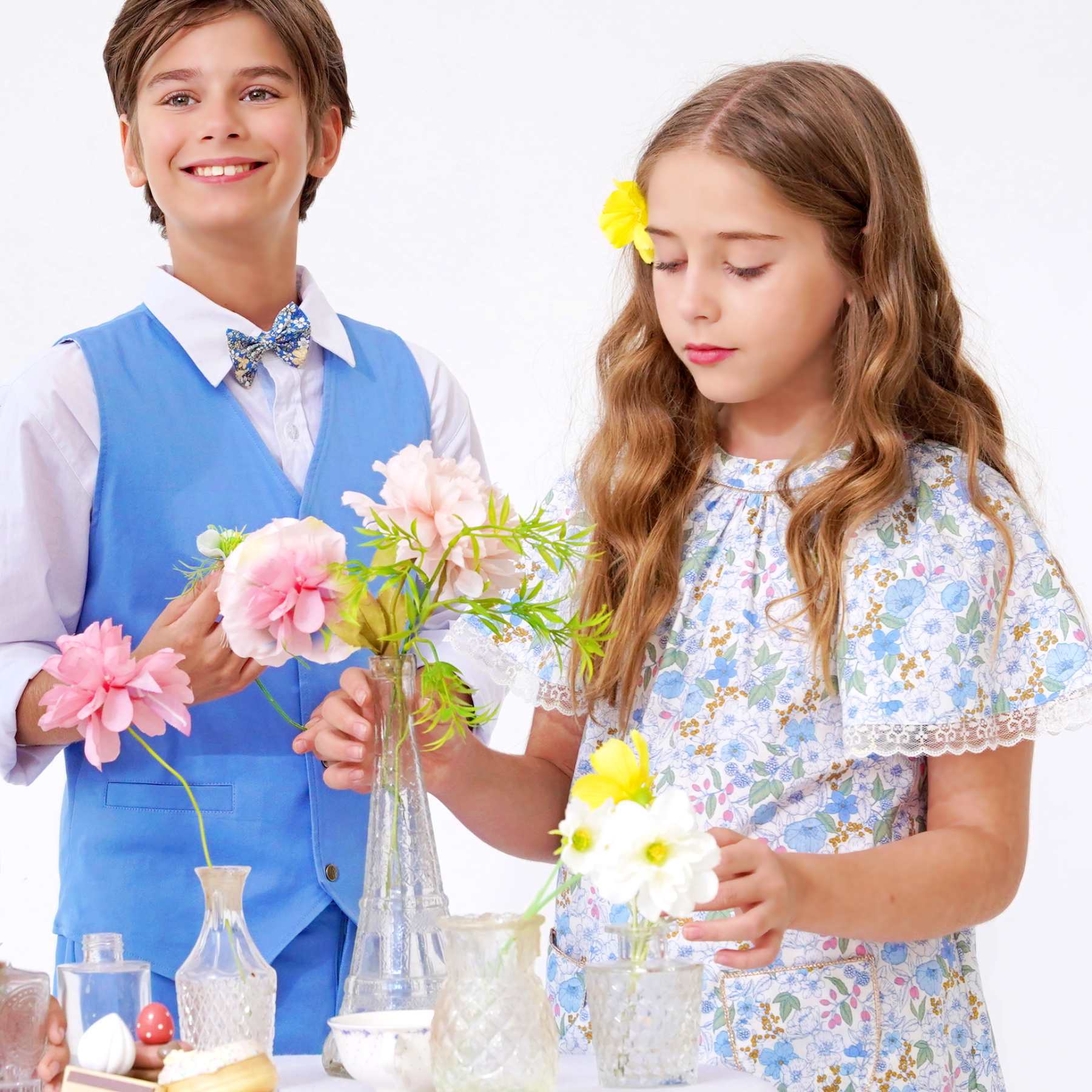 Photo de tenues portées de cérémonie avec gros plan de la robe de cérémonie fleurie liberty bleu clair Butterfly et costume de mariage garçon bleu de la marque de mode pour enfants La Faute à Voltaire.