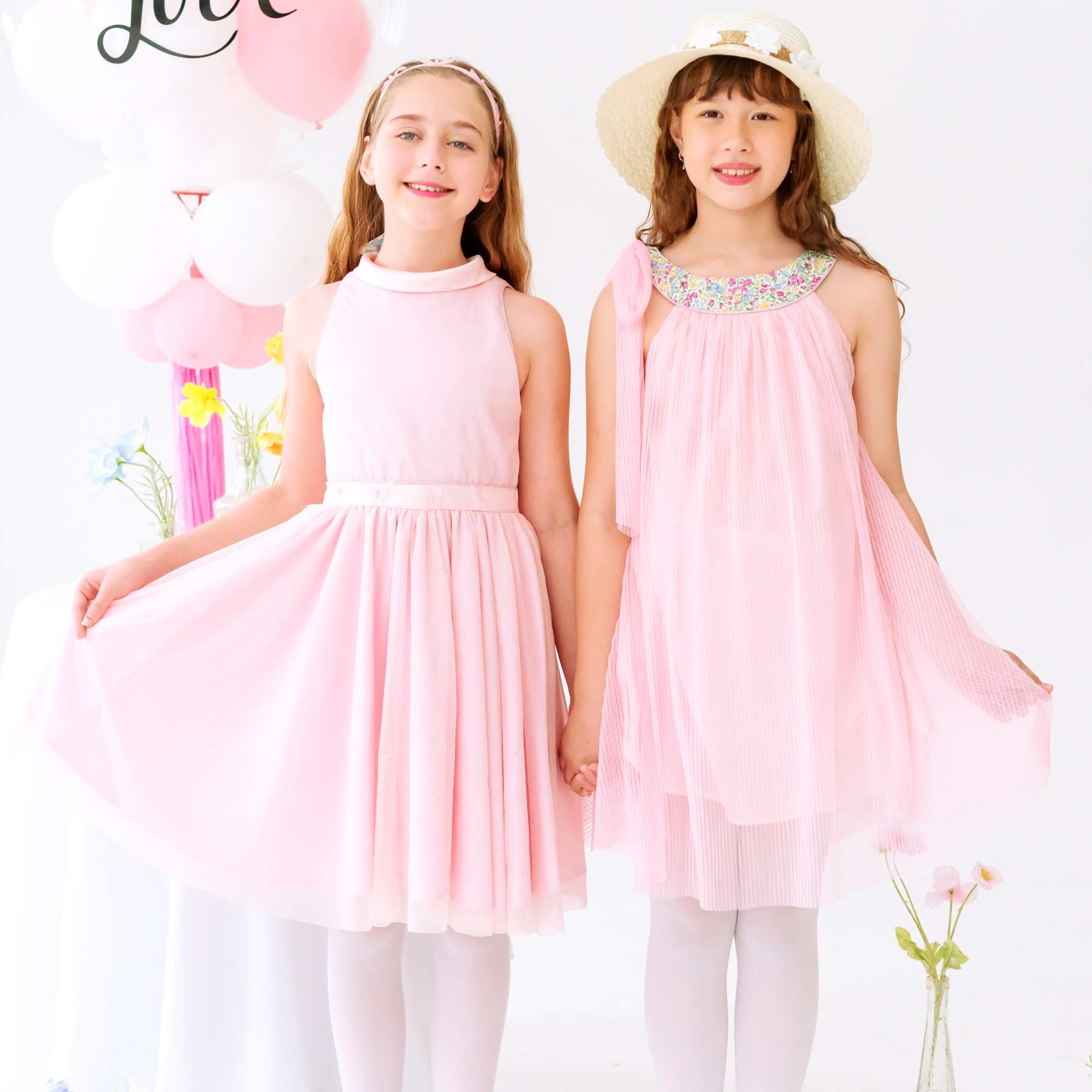 Photo portée de la Robe demoiselle d’honneur pour fille rose poudrée Hepburn, coupe patineuse avec jupe qui tourne, ceinture ornée de papillons et grand nœud au dos, tenue de mariage et cérémonie de la marque de mode pour enfants La Faute à Voltaire