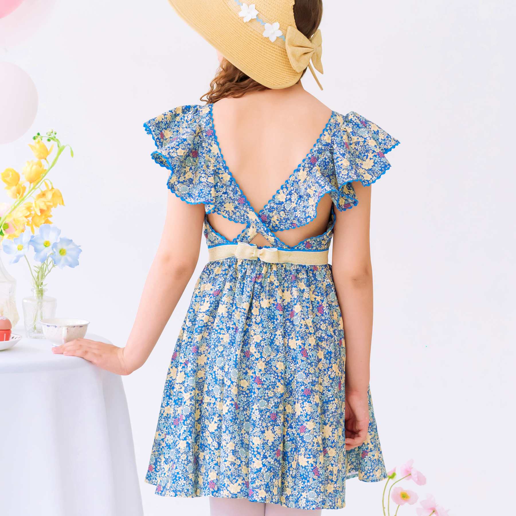 Dos bretelles croisées à volants de la robe cérémonie fille liberty bleu foncé et jaune avec manches courtes à volants, ceinture doré. Tailles disponibles du 2 au 16 ans.