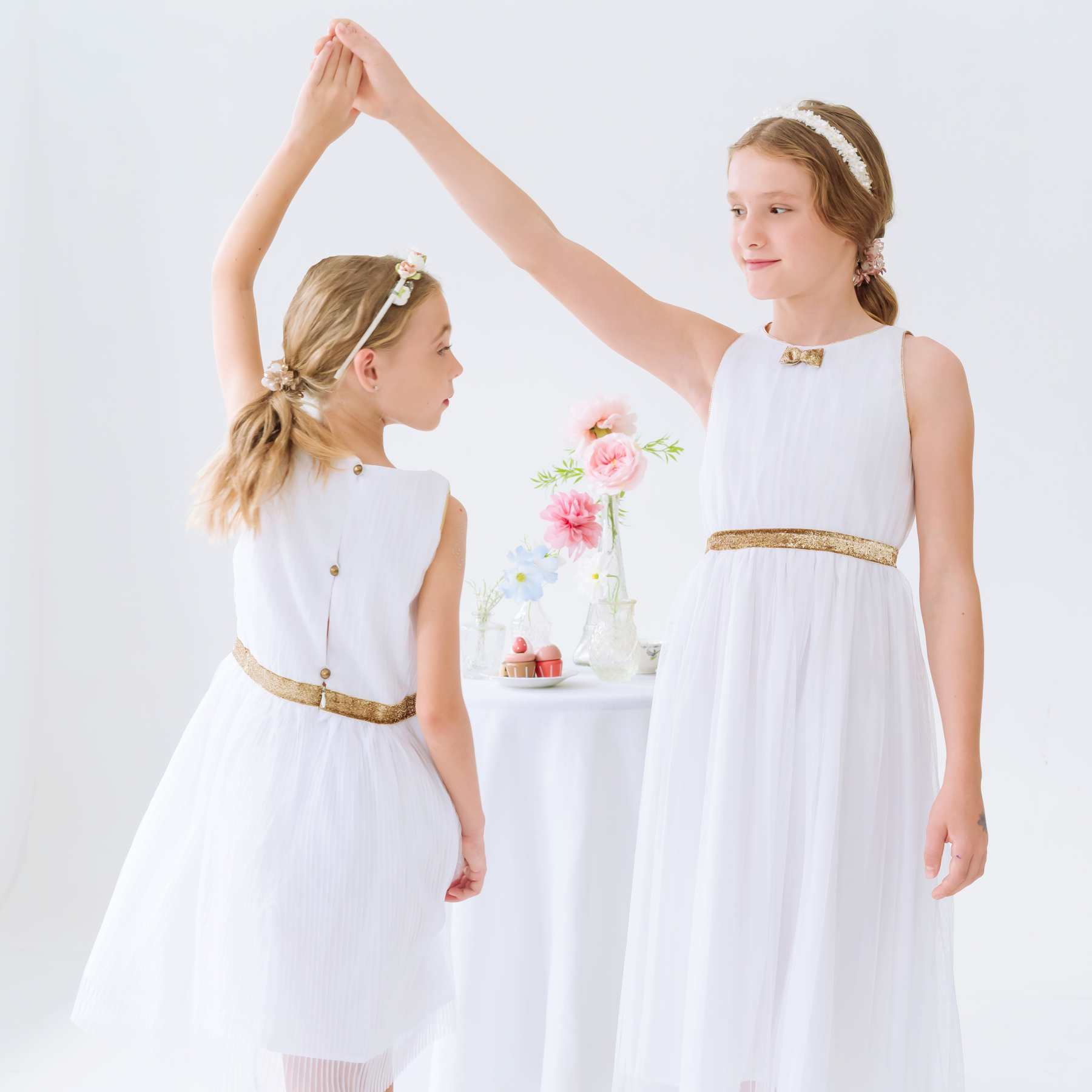 Robe cérémonie fille blanche longue en voile acrylique doublée de coton. Ceinture et noeud paillettes dorées. Ouverture dans le dos avec fermeture éclair jusqu'à la taille et boutons dorés arrondis. Idéale en robe de communion et robe de demoiselle d'honneur.