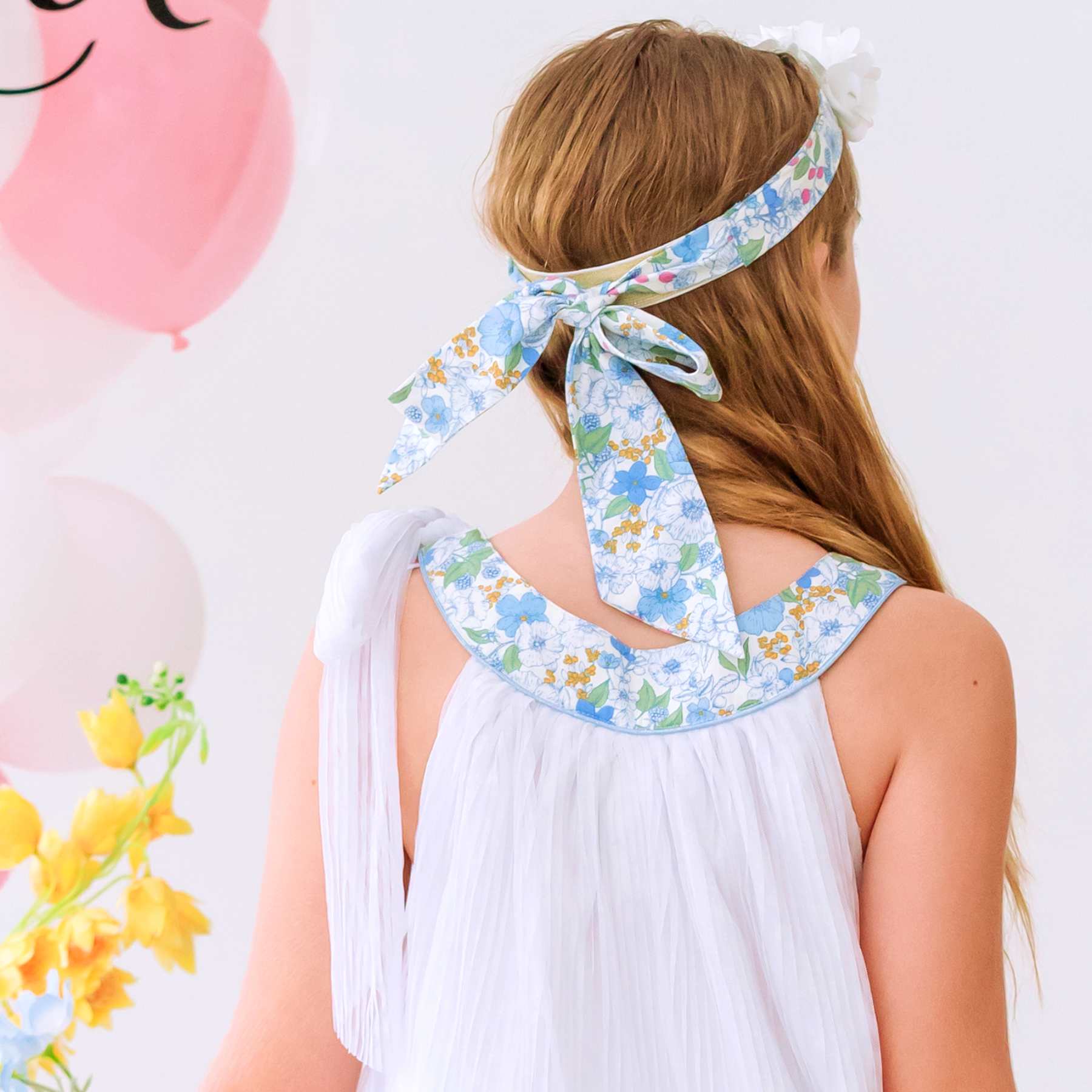 Dos du bandeau cheveux fille cérémonie fleuri bleu ciel avec fleurs blanches délicates sur l'avant, élastique doré pour un maintien parfait. Disponible du 2 au 16 ans.