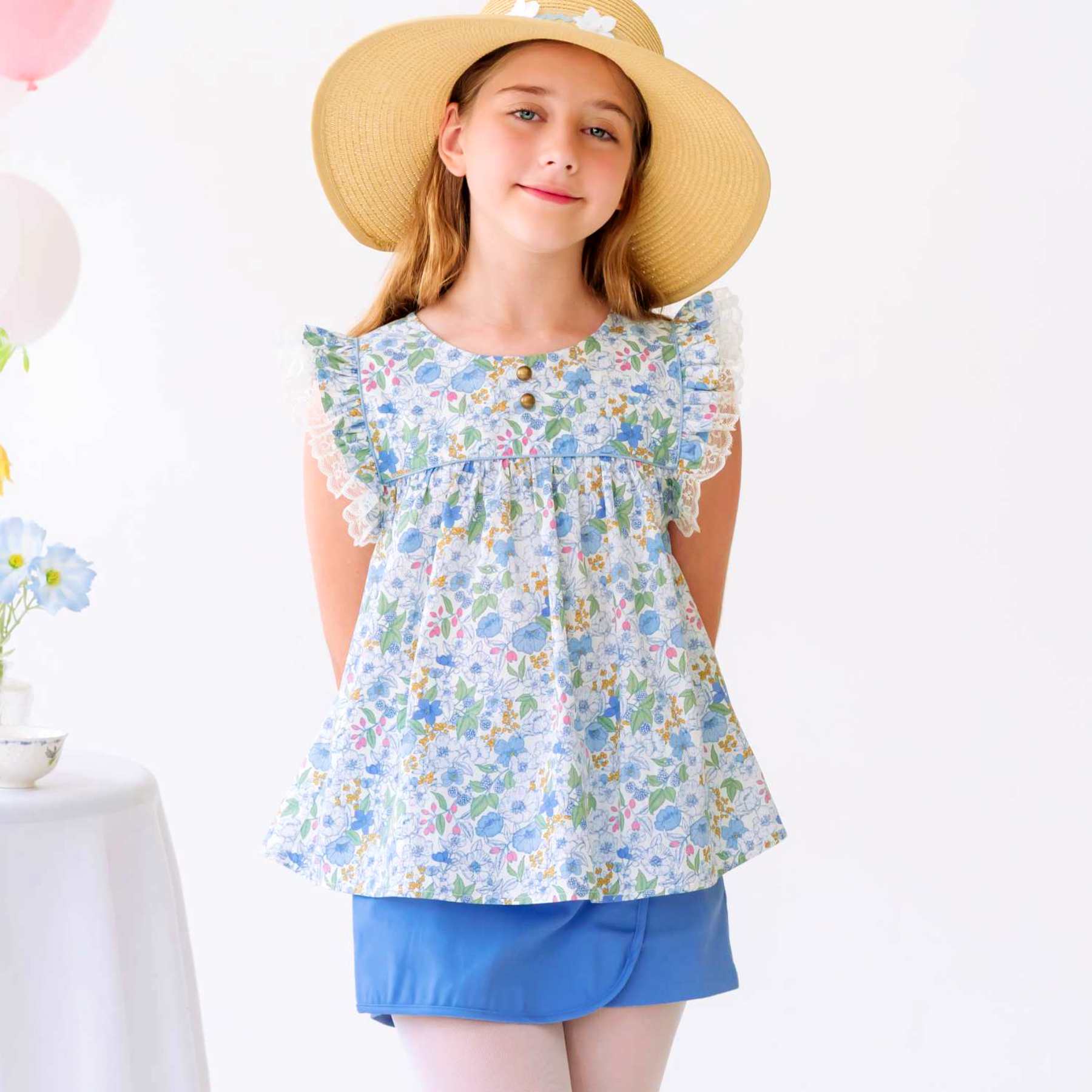 Photo portée de la jupe short bleu ciel fille avec coupe portefeuille sur le devant. Taille élastique dans le dos. Ceinture fantaisie à fines rayures multicolores. Modèle disponible du 2 au 16 ans. Taille plutôt petit. Optez pour la taille supérerieure si l'enfant est entre deux tailles ou de morphologie un peu ronde.