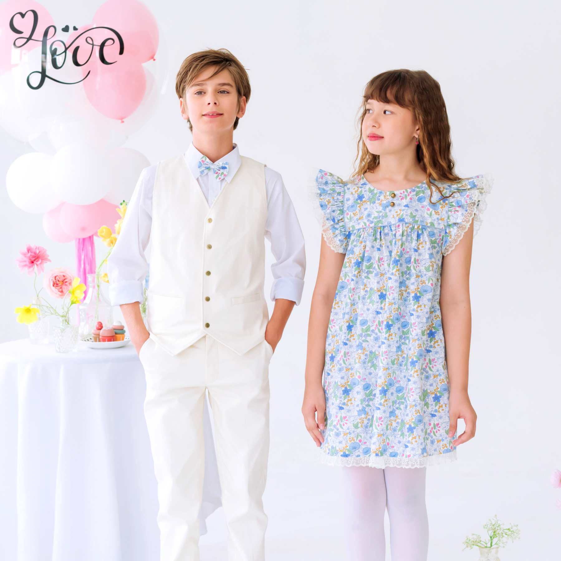 Photo porté du noeud papillon liberty bleu clair avec taille ajustable. Ce noeud papillon cérémonie est dans le même tissu liberty fleuri bleu clair que les robes de demoiselles d'honneur pour un cortège de mariage harmonieux. Disponible de la taille 2 à 16 ans.