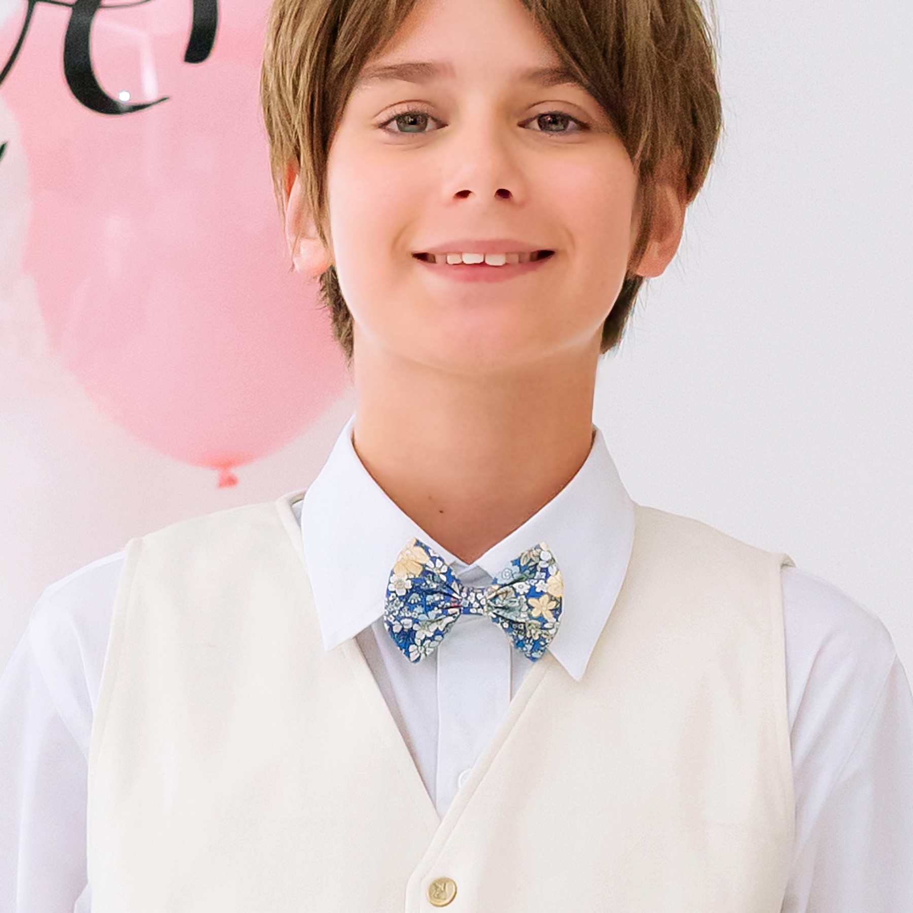 Photo portée du noeud papillon liberty garçon fleuri bleu foncé et jaune. Idéal pour les mariages et cérémonies estivales, ce noeud papillon liberty est dans le même tissu liberty que les robes de cérémonies fille afin d'harmoniser les robes de demoiselles d'honneur et costume des garçons d'honneur. Disponible du 2 au 16 ans.