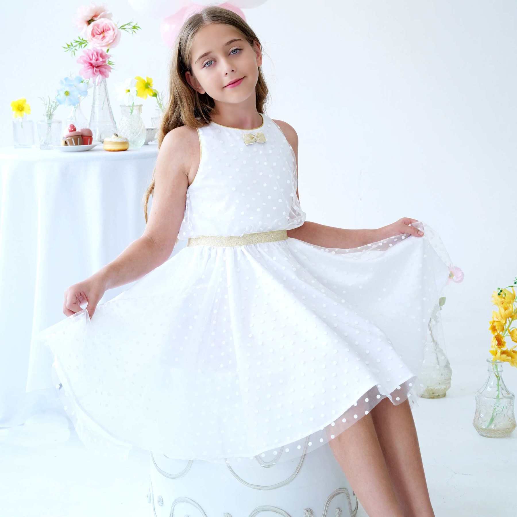 Robe cérémonie fille blanche et or en tulle. Robe qui tourne coupe patineuse avec emmanchures américaines. Coupe trapèze avec taille cintrée dorée. Robe en tulle acrylique légère et douce doublé de coton confortable. Idéale pour les demoiselles d'honneur, les communiantes et tout évènements religieux. Tailles disponibles du 2 au 16 ans.
