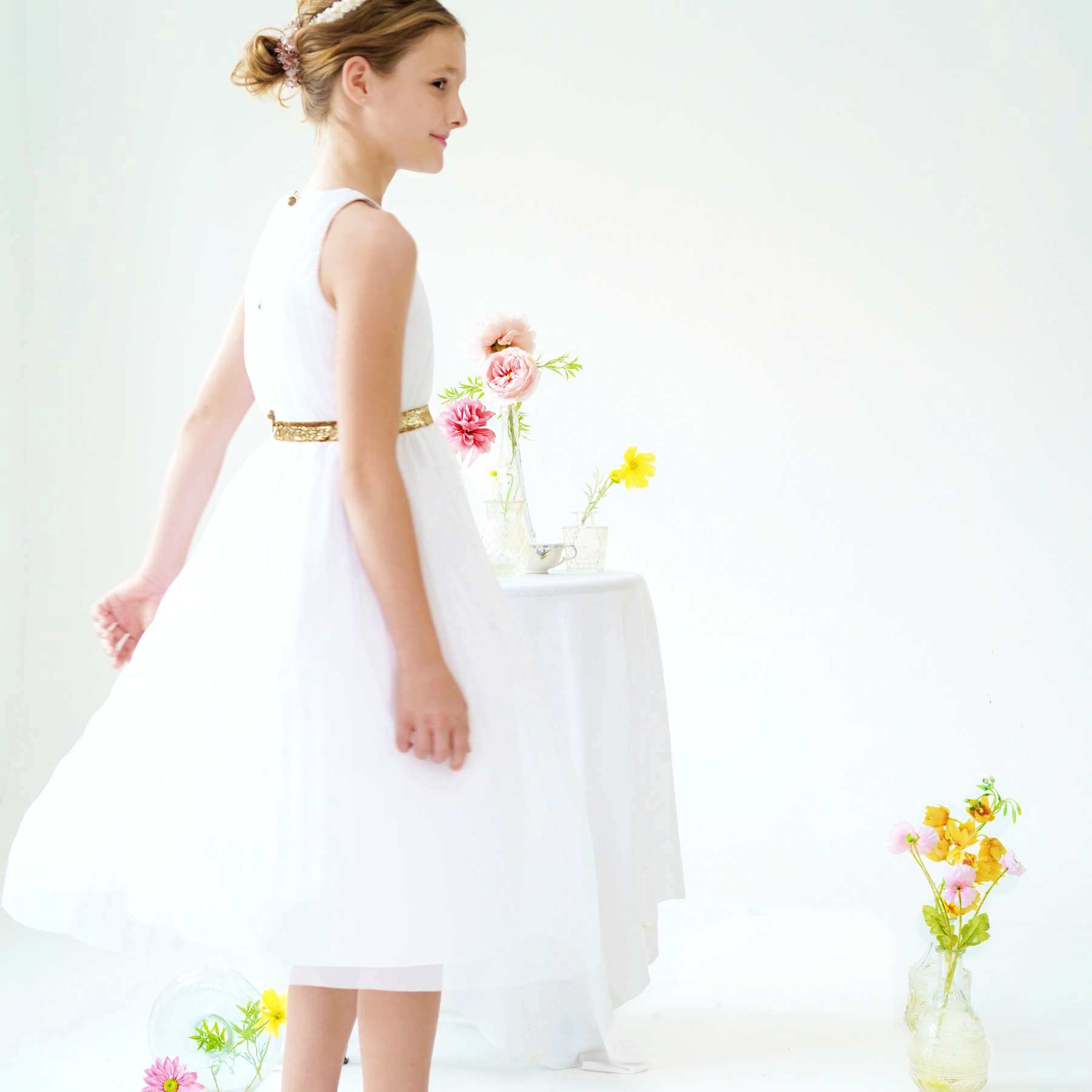 Robe cérémonie fille blanche longue en voile acrylique doublée de coton. Ceinture et noeud paillettes dorées. Ouverture dans le dos avec fermeture éclair jusqu'à la taille et boutons dorés arrondis. Idéale en robe de communion et robe de demoiselle d'honneur.