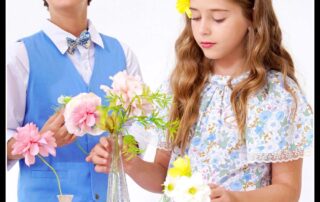 Photo portées tenues mariage enfant pour cérémonie avec gros plan de la robe de cérémonie fleurie liberty bleu clair Butterfly et costume de mariage garçon bleu de la marque de mode pour enfants La Faute à Voltaire.