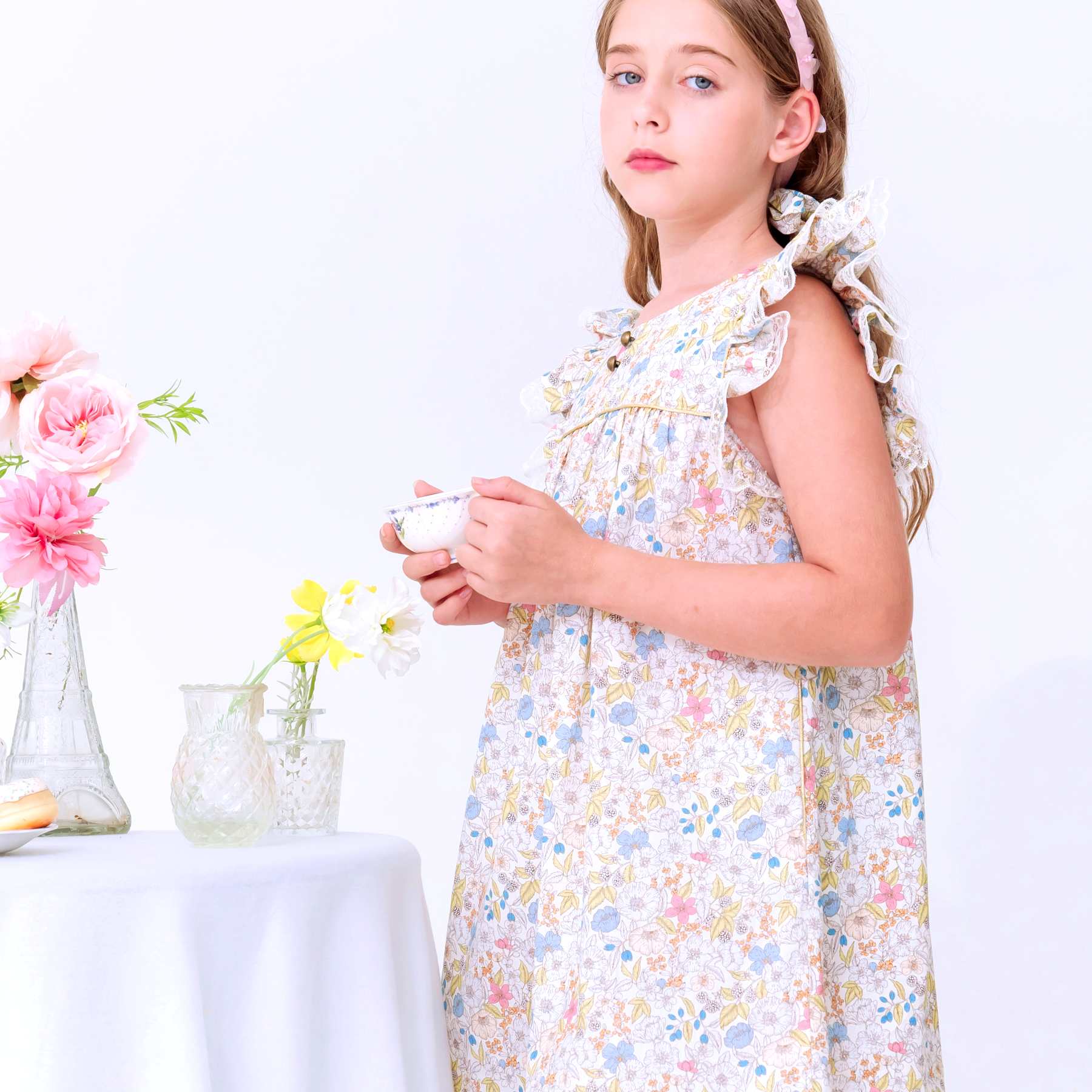 Robe demoiselle d'honneur fille fleurie liberty jaune pastel manches courtes à volants Appoline avec détails raffinées comme fine dentelle beige mordoré aux manches et biais doré sur le col. Tailles disponibles du 2 au 16 ans.